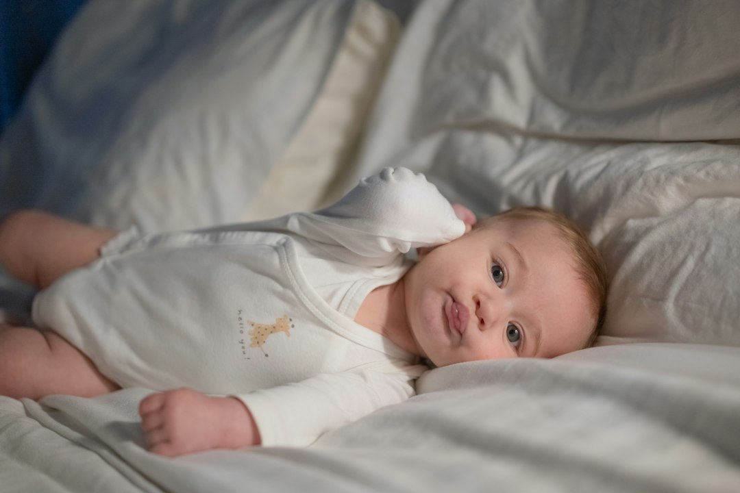 Baby lying on a bed with soft white sheets